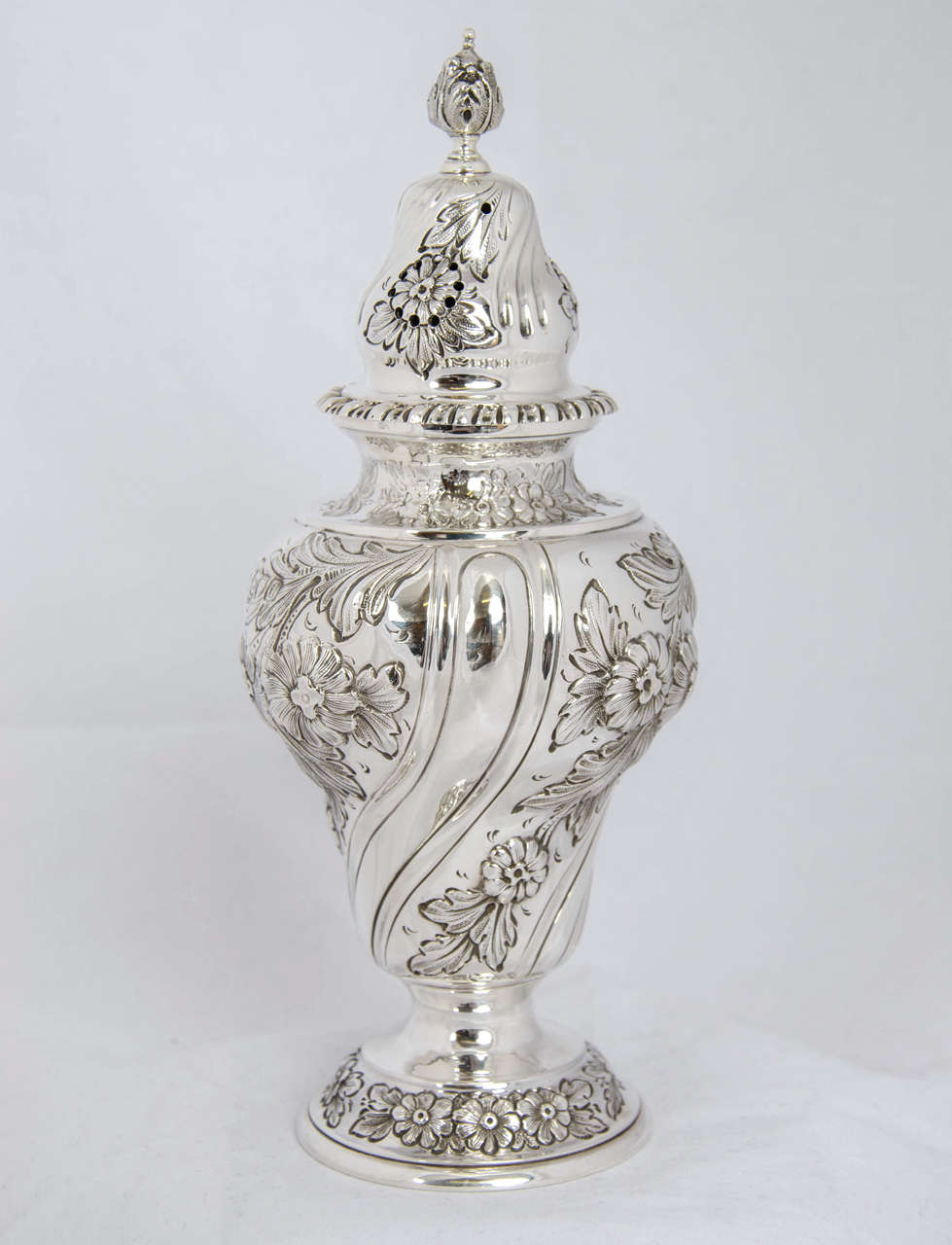 A Victorian silver sugar shaker or caster, made in London 1899 by the firm of Walter Walker & Brownfield Tolhurst.  It is beatifully embossed with flowers and swirls and stands 19.5cms high.