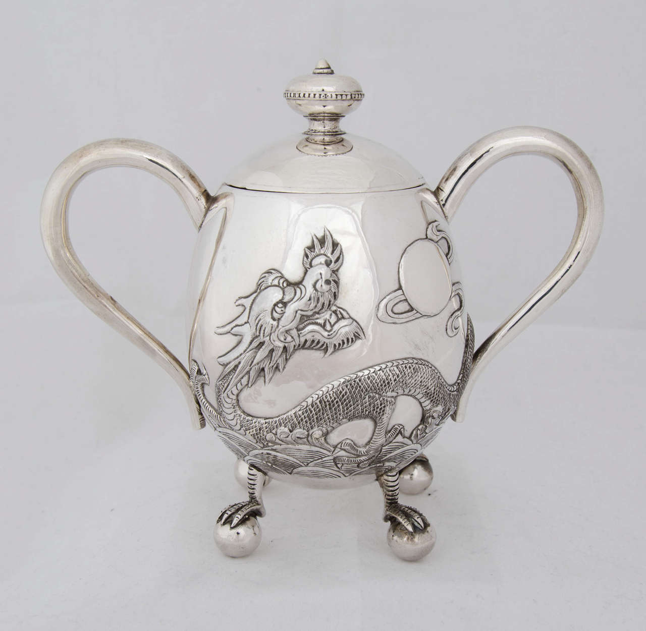 An unusual 3-piece Chinese export silver tea set
decorated with a dragon on a plain background.
Each piece sits on ball and claw feet.
Made by Hone Wo
Total weight is 1088gms.
 