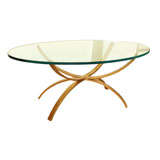 A Coffee Table with Oval Glass Top and Arching Gilt Iron Base