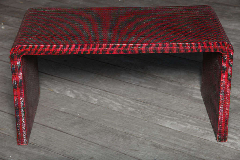 An American Karl Springer style linen wrapped coffee table with waterfall ends having red painted finish.