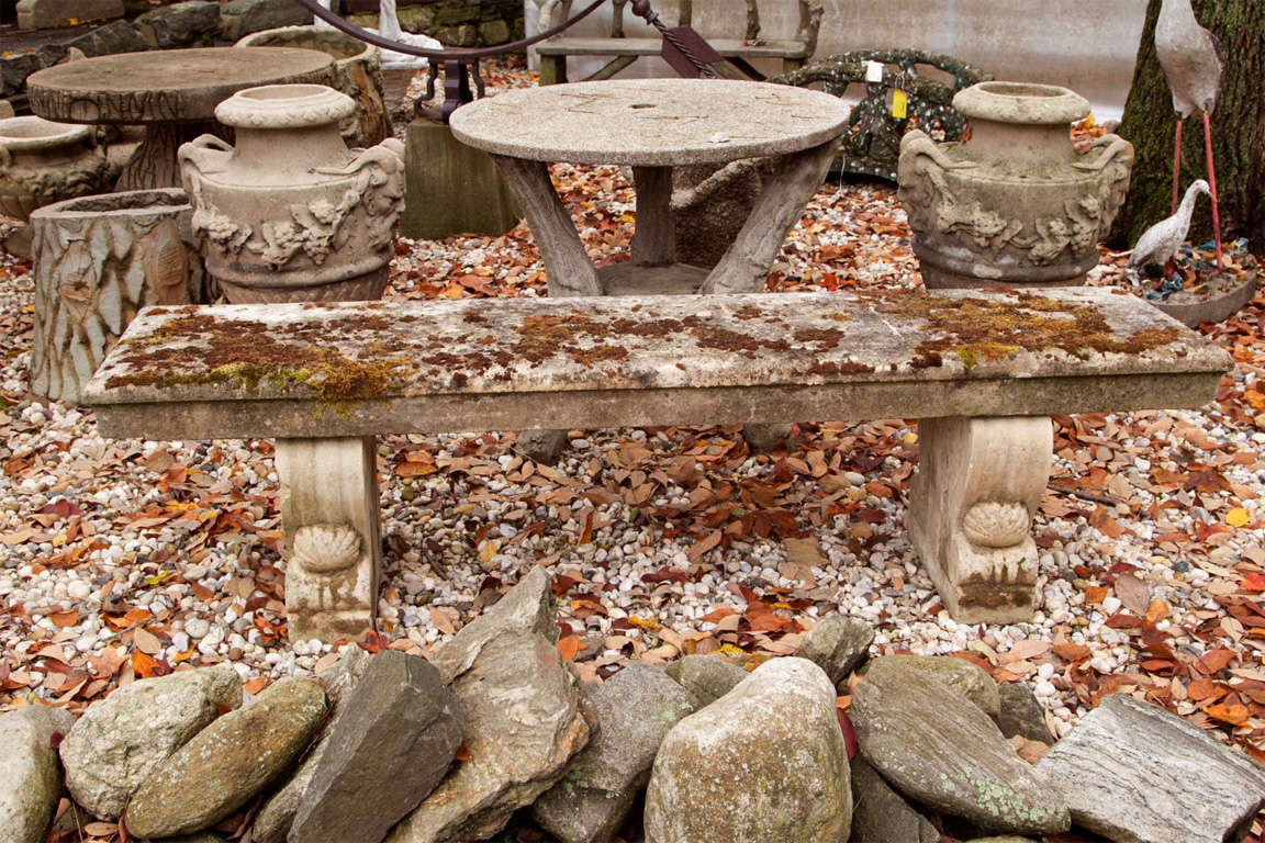 Long stone garden bench with two decorative supports