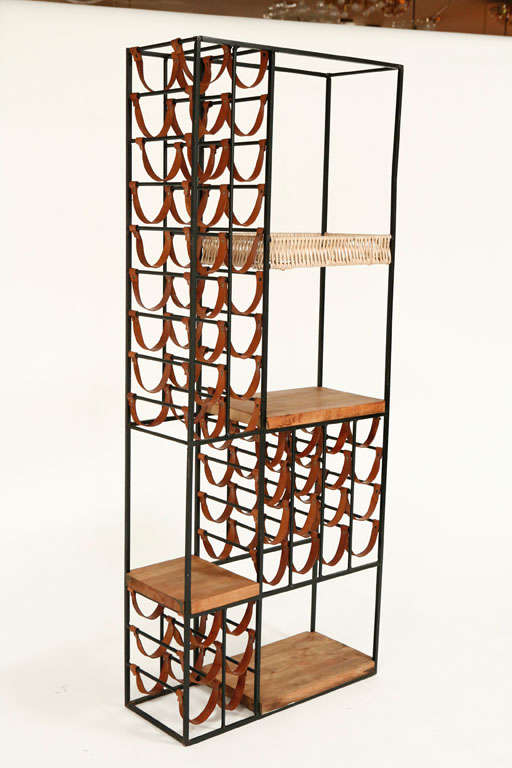 Large Paul McCobb wine rack wall unit constructed of leather, iron and butcher block wood. 4 separate surface spaces and holds 38 bottles of wine. Great function and craftsmanship.