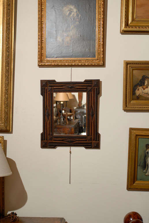 A petite French late 19th century Dutch style Tramp Art mirror. This petite Tramp Art mirror, circa 1880 comes from France and features a finely carved frame surrounding a new glass mirror. It is a great example of the Tramp Art style, an art