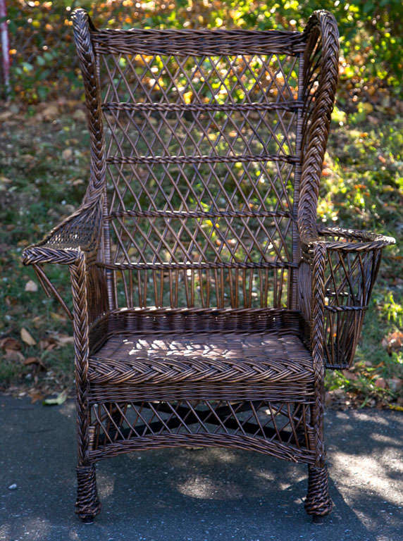 Willow Wing Back Wicker Chair in natural finish with magazine rack and woven feet.