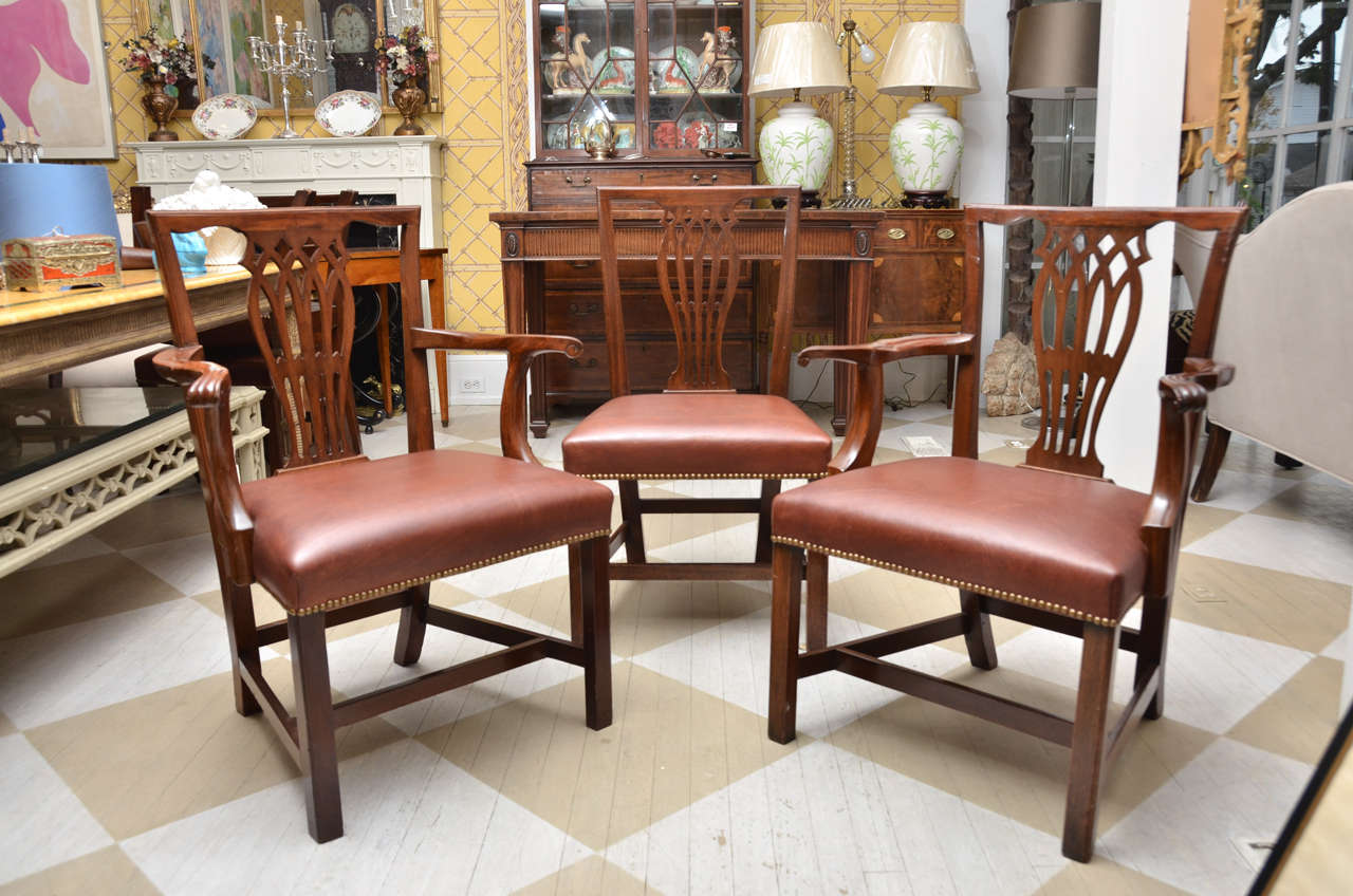 Late 18th-early 19th century English set of 12 mahogany dining chairs, ten side chairs and two armchairs
having brown leather seats with brass tacks.