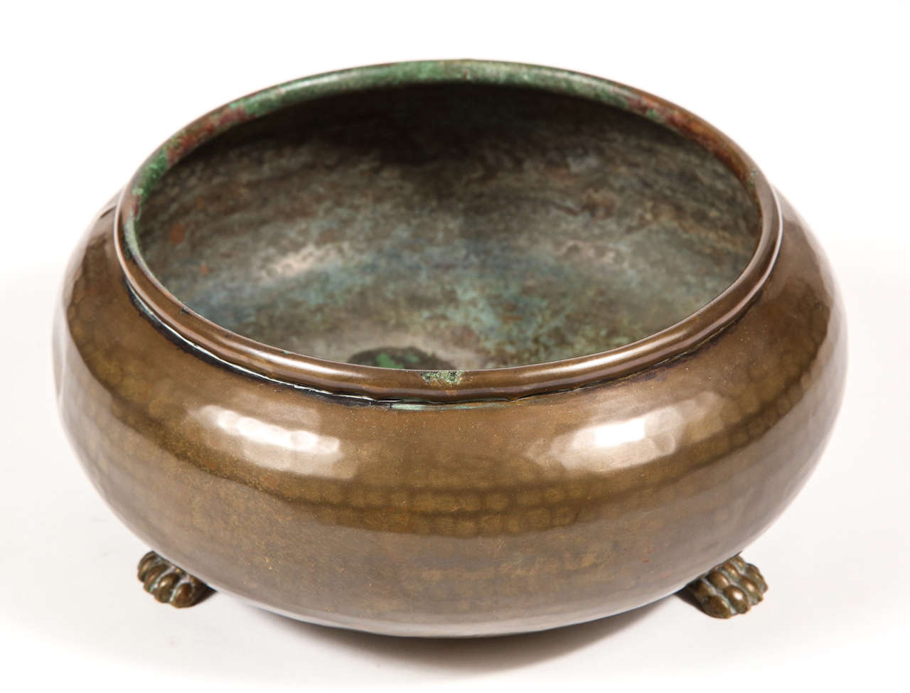 Hammered brass tone metal pot with light verdigris patina and paw feet.