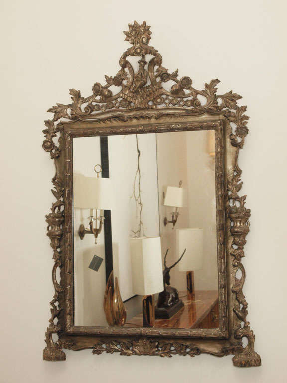 Pair intricately carved and silver-gilt mirrors, each with a crossed-legged figure poised at the top crest