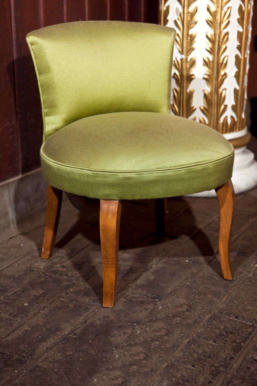 French vanity chair in olive green fabric with curved wood legs.