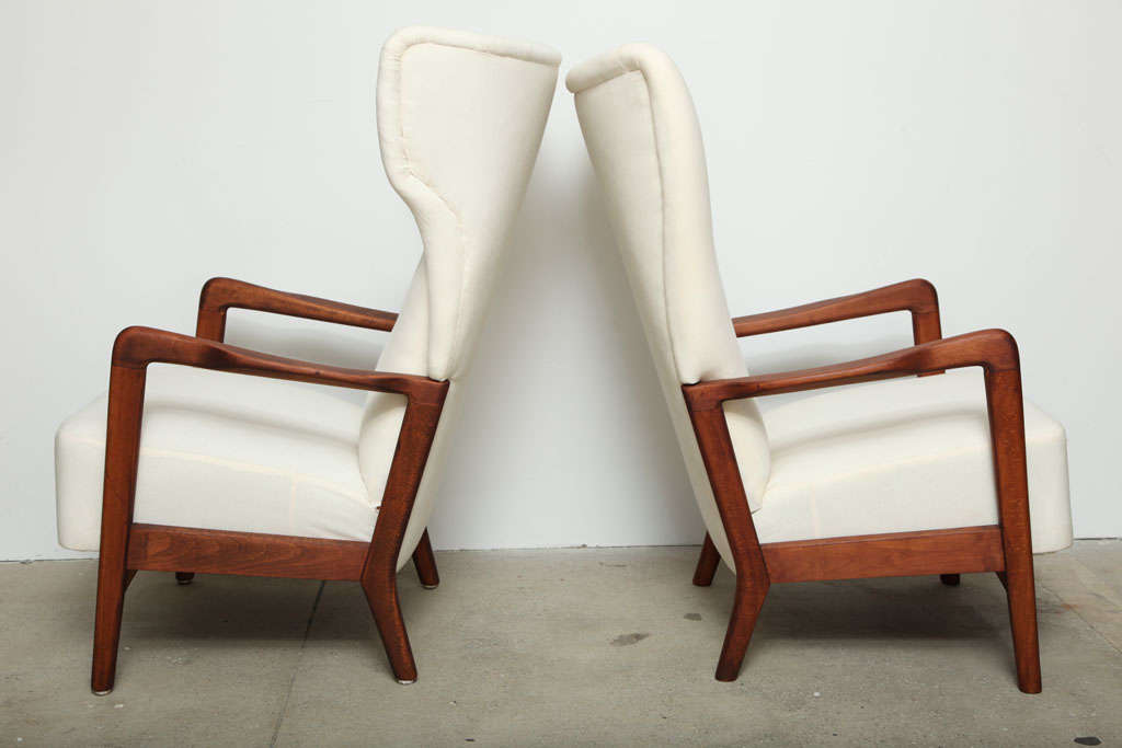 Pair of Danish modern high back his and hers chairs. These chairs have been upholstered in new muslin and the beechwood frame has been refinished in a beautiful walnut stain.