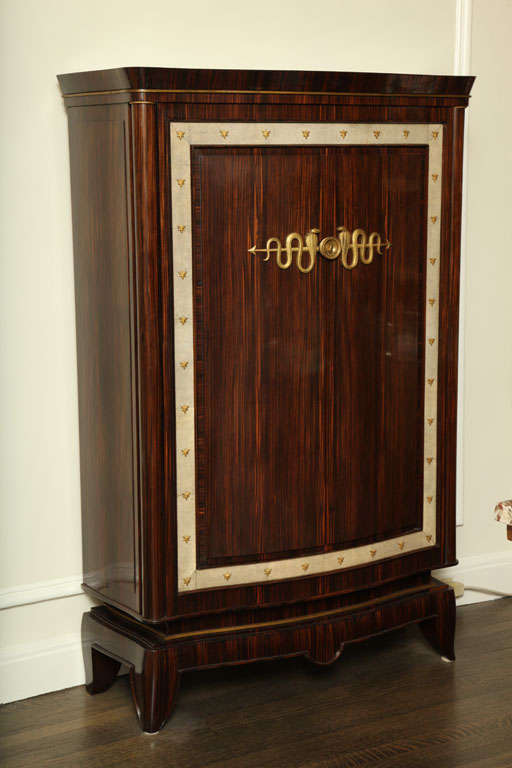 This macassar ebony cabinet has two doors which are surrounded by a strip of white shagreen and decorated with gilt bronze ornaments. 

Frechet was director of the Ecoule Boulle in Paris. He participated from 1921-1935 at the Salon des Artistes