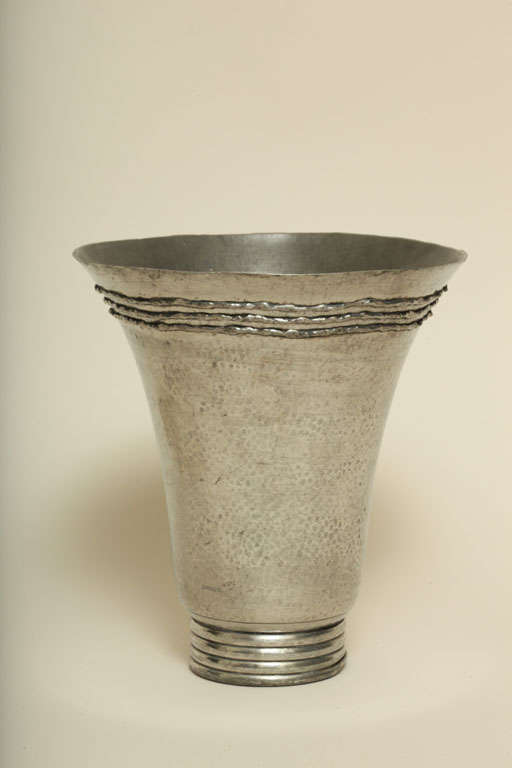Hand-wrought pewter martele´ vase with a base of four circular bands and flaring top with three applied circular metal bands by Rene´ Delavan (active 1926-1958), Paris.
Signed: "R. Delavan"
Hallmarks: R DELAVAN/ DECORATEUR/ Paris/ ETAIN