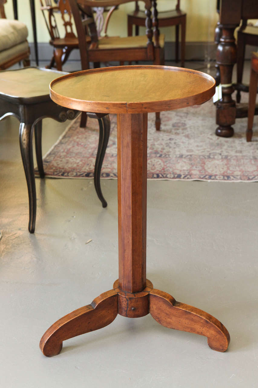 A French walnut stand or table, circa 1840 with a lovely, warm patina. Please note the scissors imprint on the top of the stand, add to the charm of the piece.