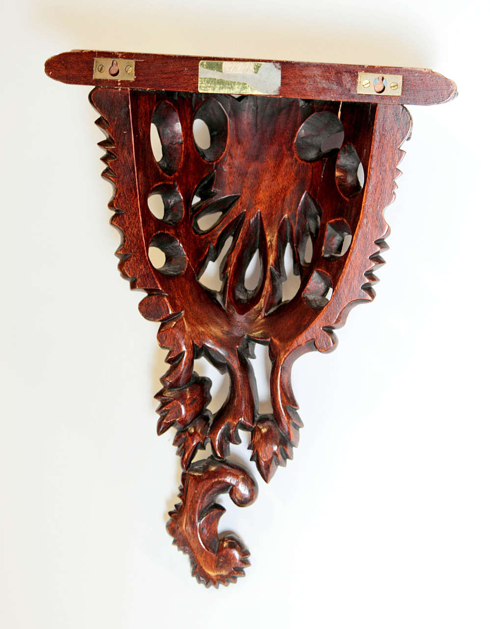 Pair of mahogany-stained finely carved Rococo-style brackets.  Pierced scrolling leaf detail and carved edging on semi-circular shelf.