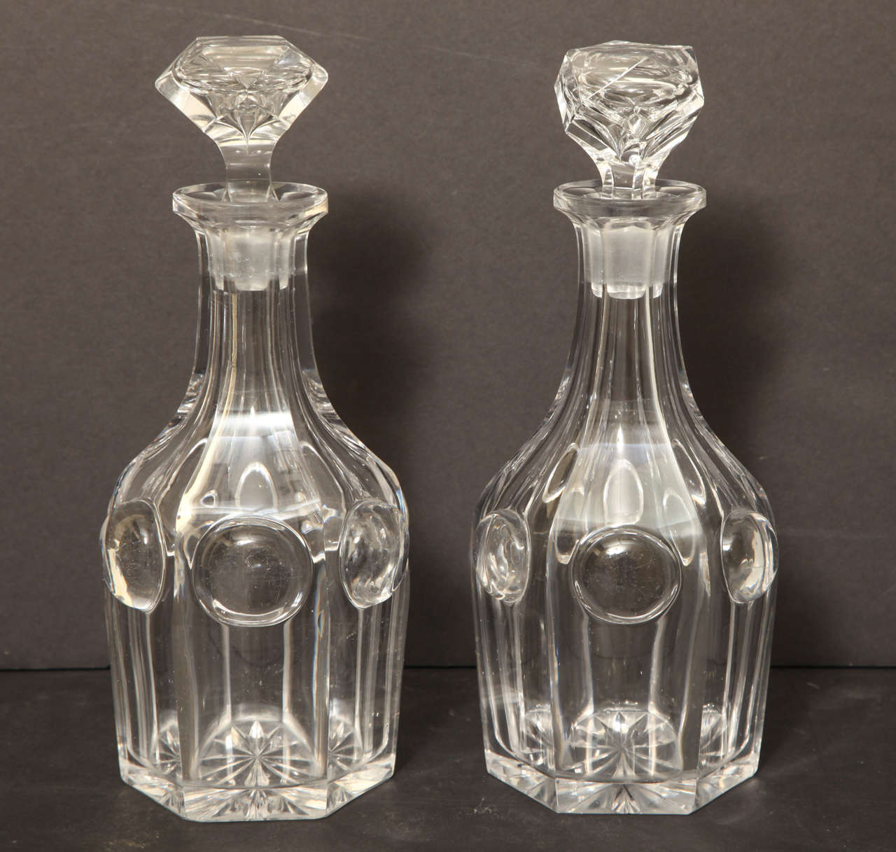 Cut Crystal Decanters With Clear Raised Lenses And Faceted Stoppers.