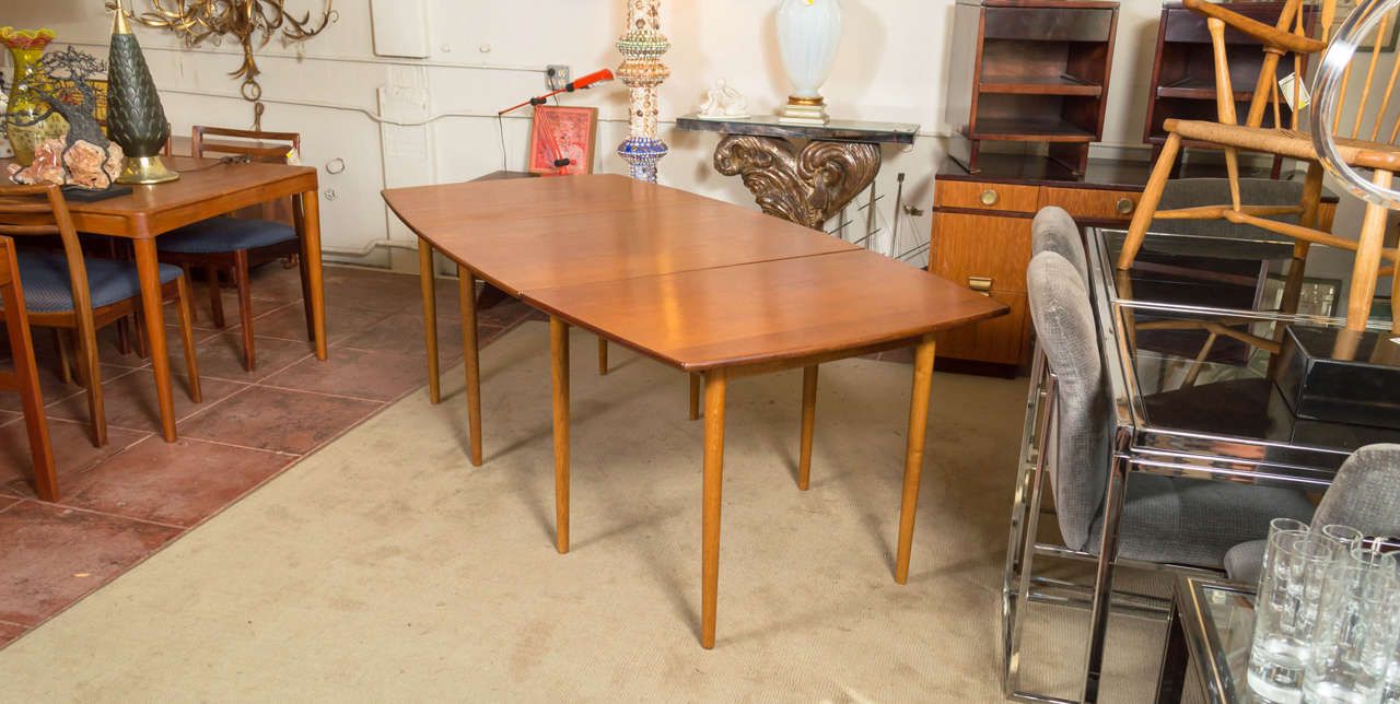 A rare Danish Modern drop-leaf teak dining table by Hans J. Wegner for Andreas Tuck.

Has four pairs of legs, two of which remain inconspicuously tucked away until needed. Double or triple the surface area by lifting up a leaf and pulling out its