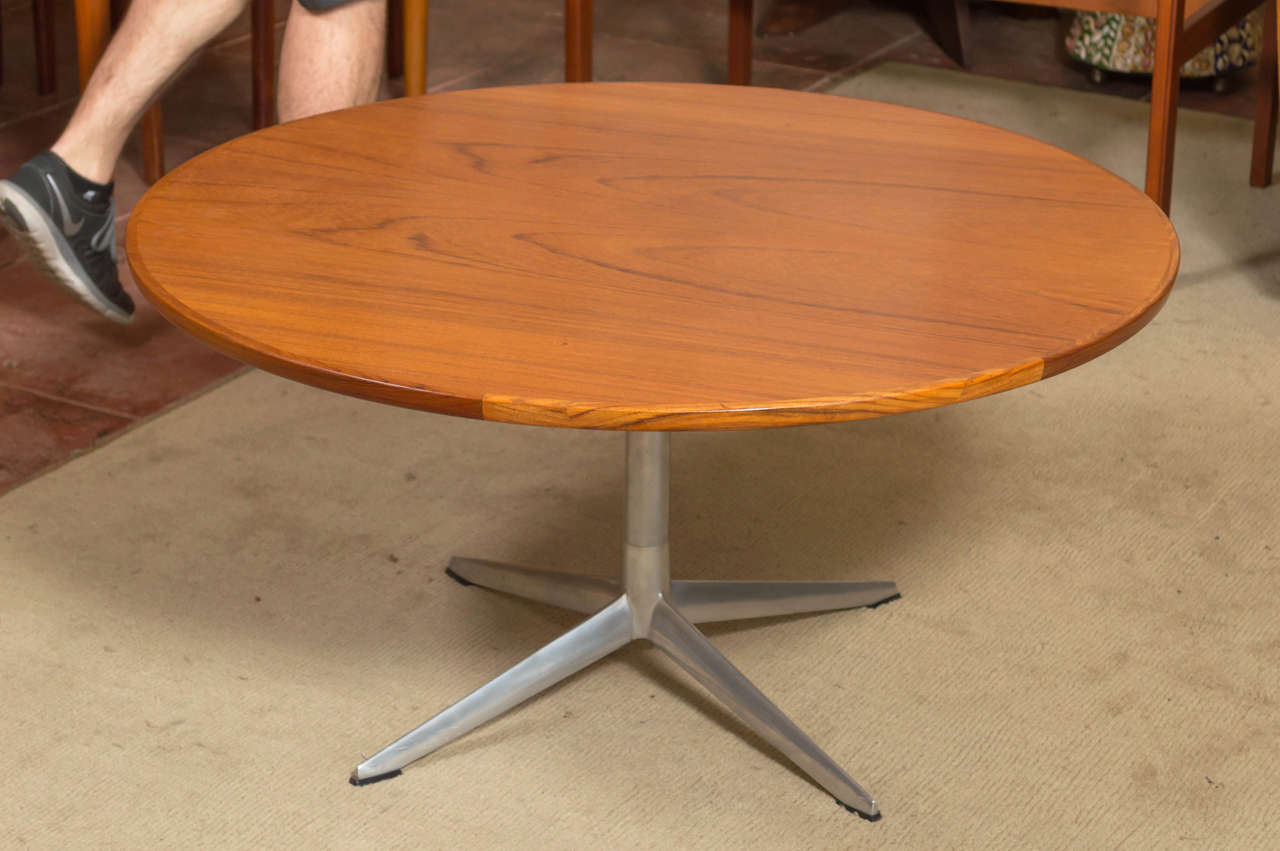 A Danish Modern round teak coffee table with aluminum base by Henry Walter Klein for Bramin Møbler.

Spacious top displays expressive bookmatched grain and has a nicely finished edge. On sleek Eames-style polished cast aluminum base. Super clean