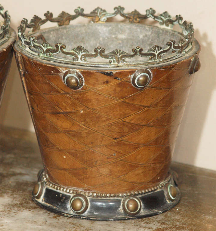A pair of cachepots with bronze gallery and cabuchons, the veneer in a lozenge design, all on an ebonized base.  Original liners.