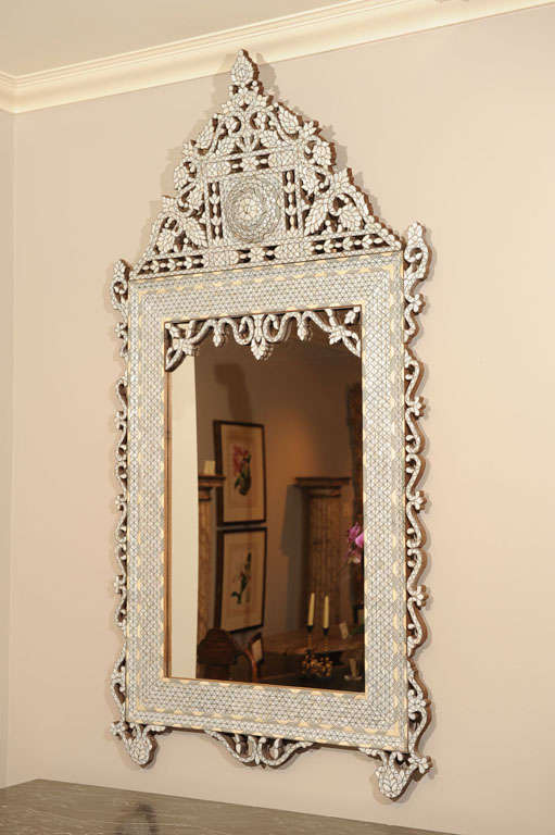 Mid 20th Century Hand Carved Inlaid Moroccan Mirror with Elaborate Mother of Pearl Diamond Inlay with Ivory Bands. The Arched Pierced Pediment Top with Scrolling Leaves Around a Raised Medallion Continuing Along the Sides and on Mirror Plate. Circa