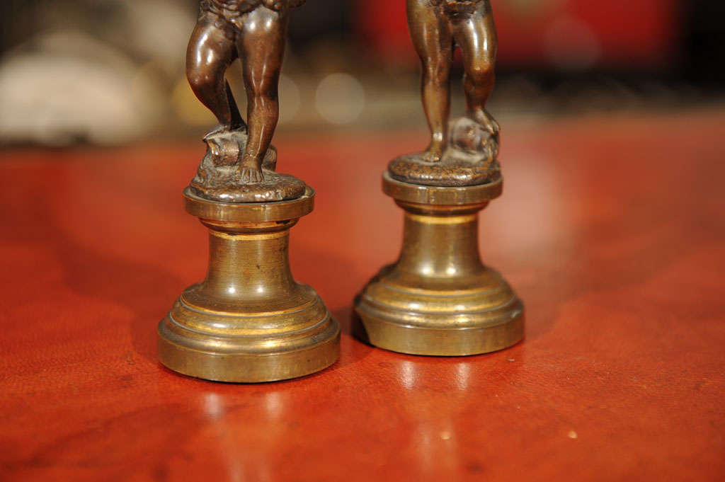19th Century Pair of Patinated Bronze and Parcel Gilt Putti-form Candlesticks For Sale