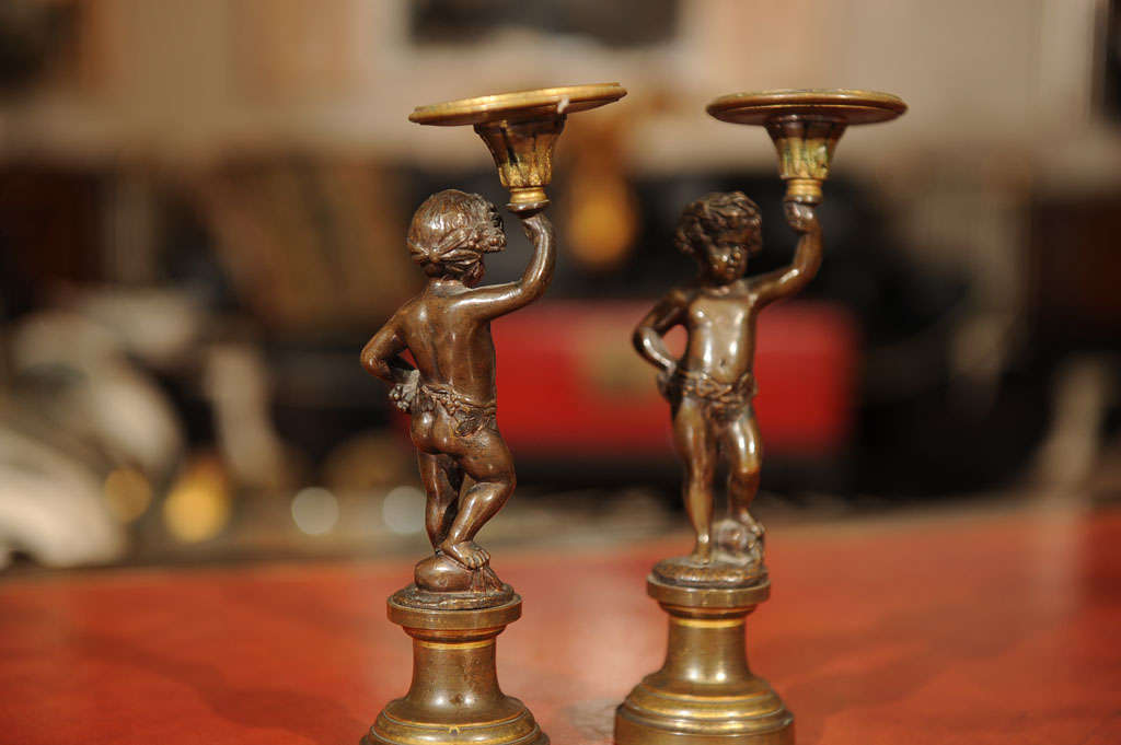 Metal Pair of Patinated Bronze and Parcel Gilt Putti-form Candlesticks For Sale