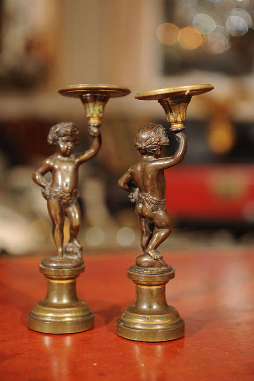 Pair of Patinated Bronze and Parcel Gilt Putti-form Candlesticks For Sale 1