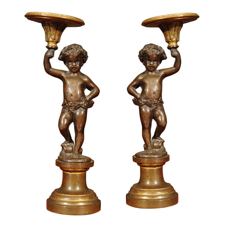 Pair of Patinated Bronze and Parcel Gilt Putti-form Candlesticks For Sale