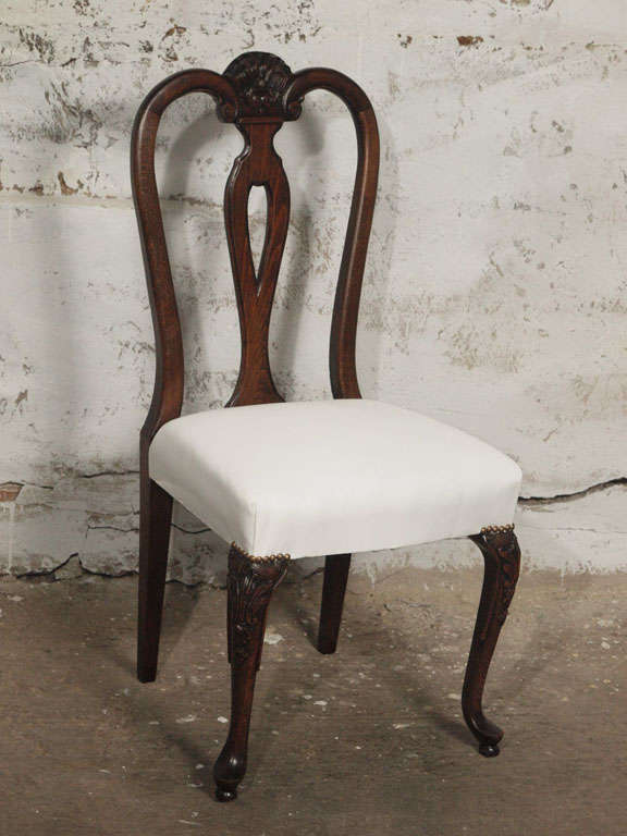 These early 19th Century country French dining chairs have been completely restored to their original beauty and solid structure. Hand-carved details on back and on cabriole legs and shaped splats.  Seats were restored with new springs, 8 way hand