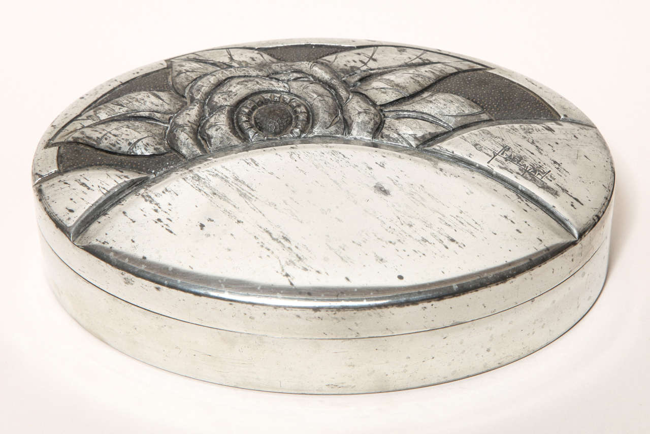 Hand-wrought dinanderie oval pewter covered box with design of a flower.
Signed: ''R. Delavan'' on body
Stamped: ''ETAIN GARANTI'' underside

Variety of other Rene Delavan pieces available.