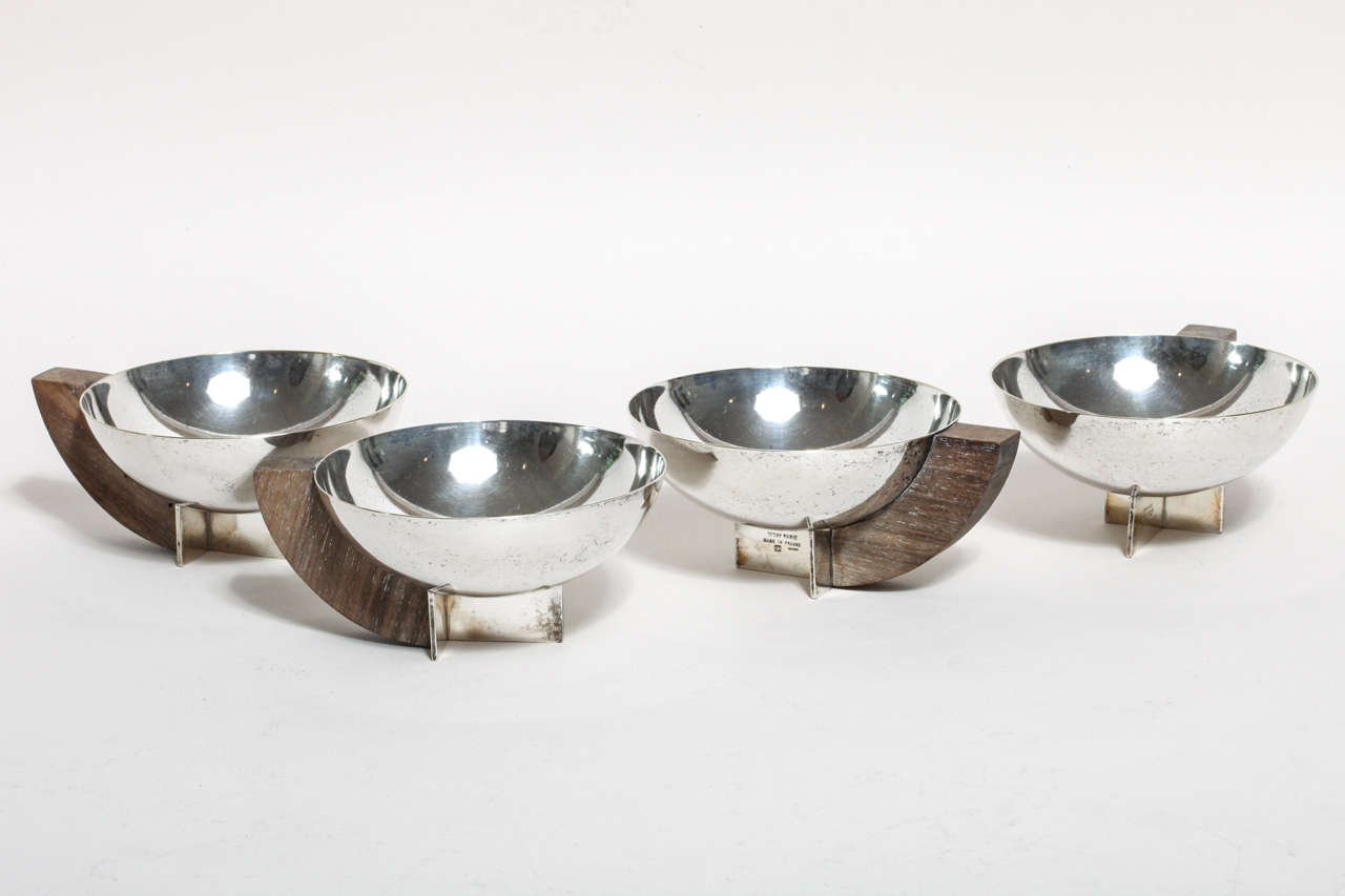 Silver metal cups raised on silvered metal base with wood handles
Stamped DESNY PARIS/ MADE IN FRANCE/ DEPOSE

M. Desnet and Clement Nauny (1900-1969), who in 1927 with the financial backing of M. Tricot, established La Maison Desny, its name a