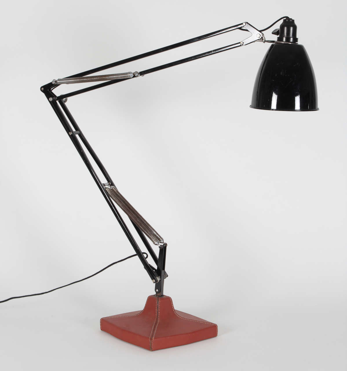 Black lacquered Anglepoise lamp with saddle-stitched tan leather covered base.