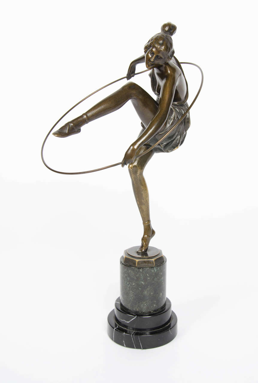 Hoop dancer, an Art Deco cold painted bronze figure of a scantily clad young lady in flowing costume dancing with a hoop by Bruno Zach (1891-1935). Silvered and richly patinated. Set onto a circular bi-colored marble plinth.

Signed Zach to