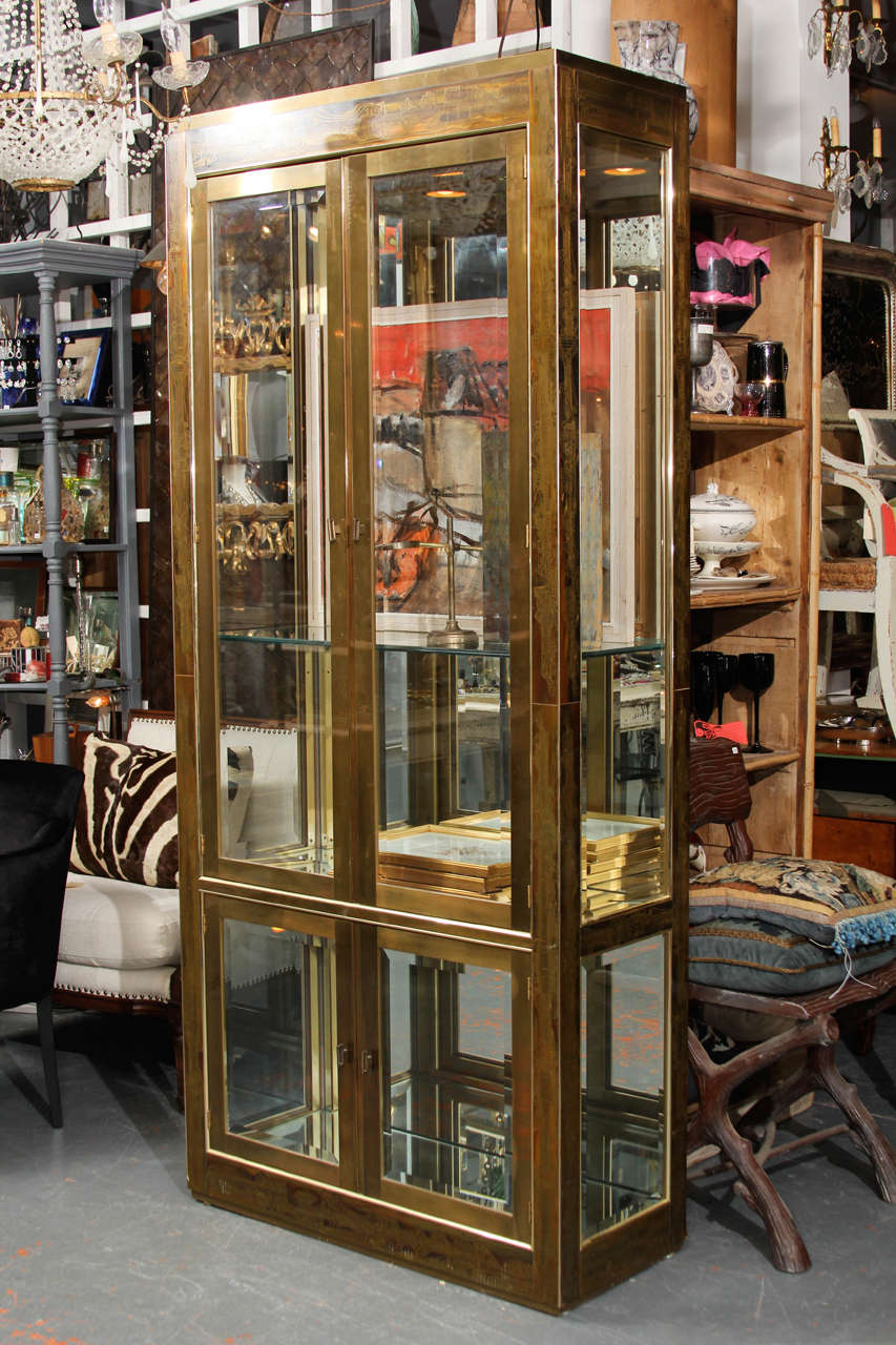 Single acid etched brass vitrine Bernhard Rohne for Mastercraft.
Brass over wood, mirror back interior, illuminated by two recessed fixture in top.