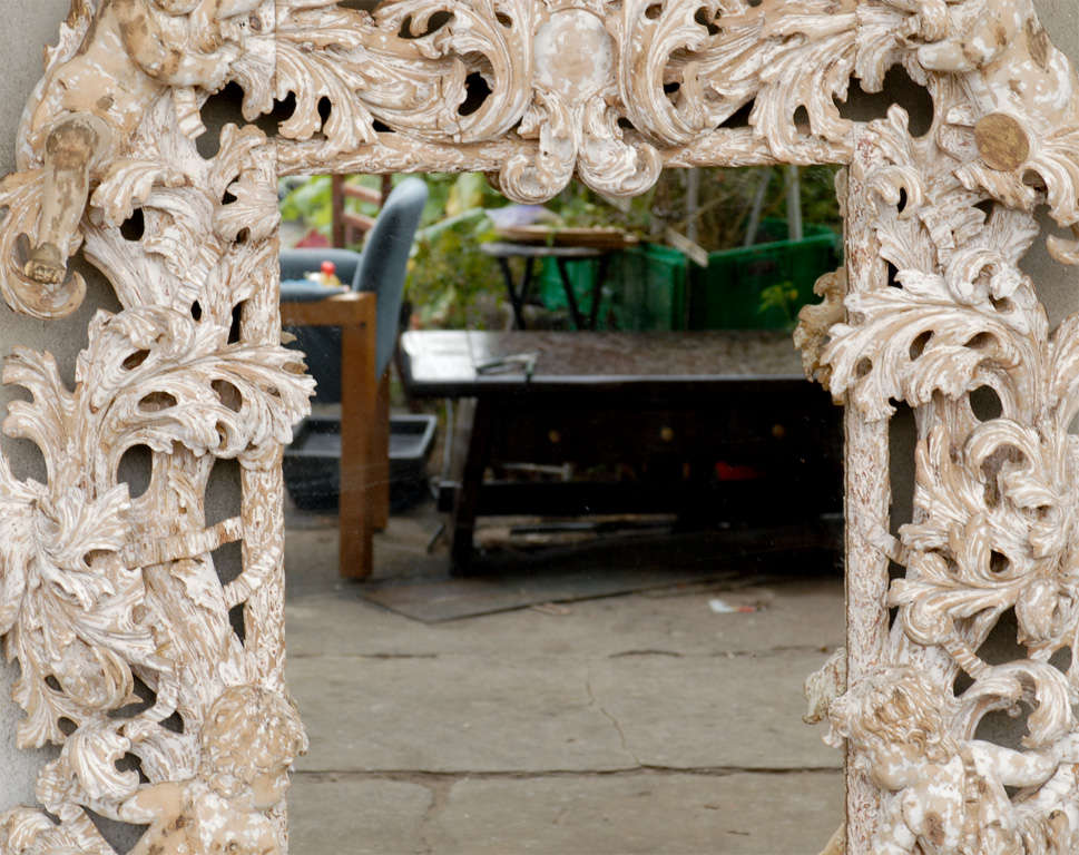 An exuberantly carved mirror with figures. Replaced glass.