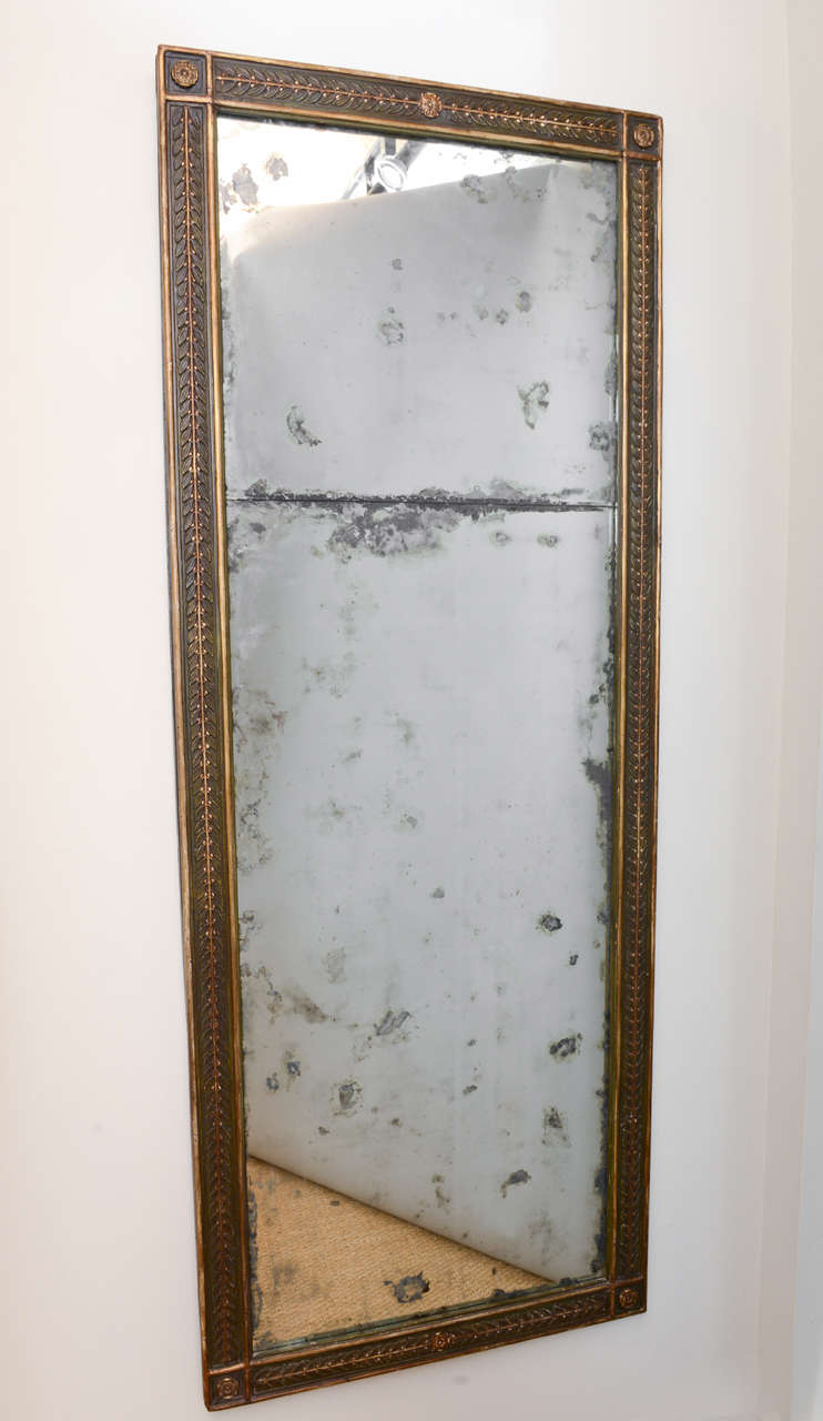 Large rectangular mirror, with polychromed and parcel gilt finish, having a fielded frame with foliate carving centered by flowerheads, and rosette corners, tax-line divided mirror plate.

We are pleased to assist by obtaining shipping quotes on