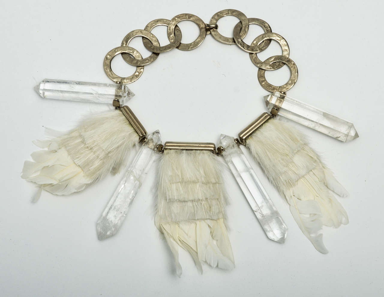 Superb hammered-silver links and bars with four crystal double-pointed obelisks, separated by white feathers held by silver bars. A statement necklace of geometry, textures, materials and glamor. Prominent label.