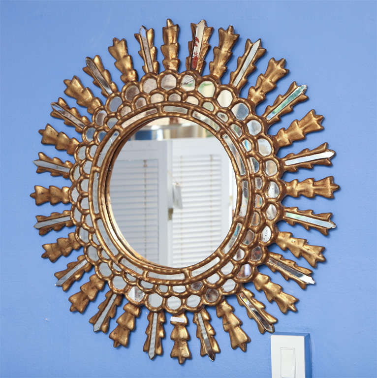 Beautiful carved gilt mirror with glass mirrors and lots of wood details.