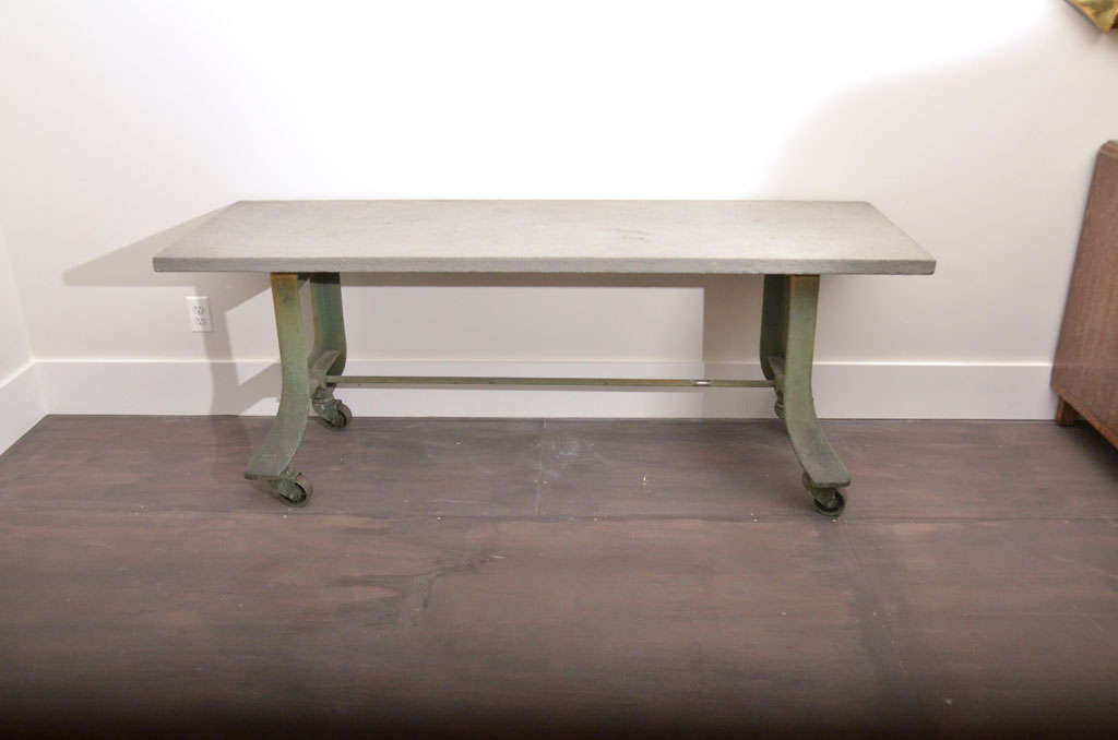 Vintage green metal table base with casters, bluestone top.