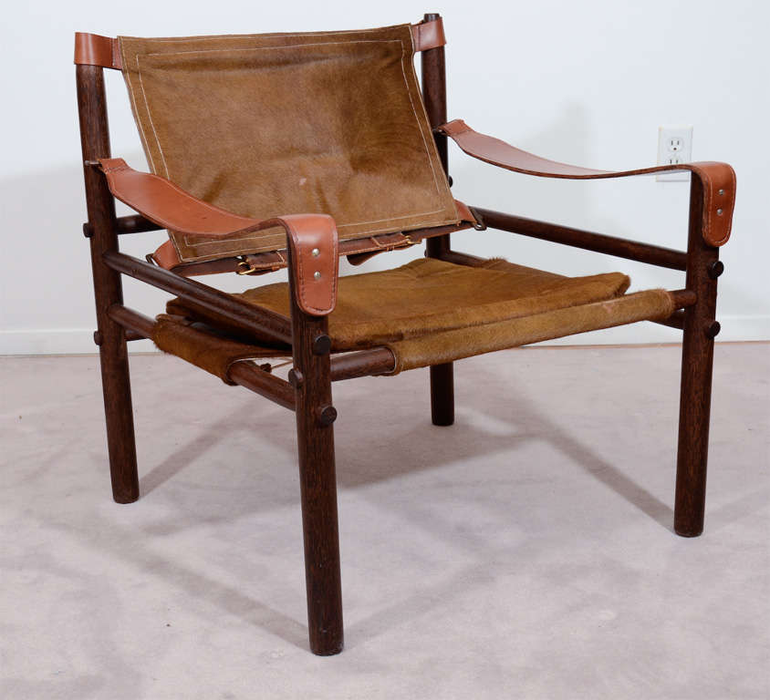 A single wood frame safari style Sirocco chair by Arne Norell. The piece has leather arm rests and furry animal hide seat and back.