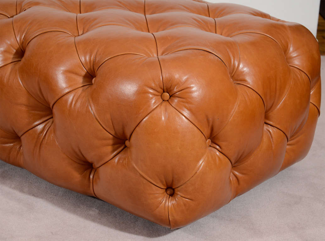 A tufted leather bench or ottoman in the style of a traditional chesterfield sofa. The piece is by George Smith.