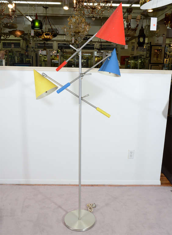 An Italian floor lamp in stainless steel with three multi-colored articulated lights. Each light pivots up and down on a bar and also swivels and pivots at the shade.