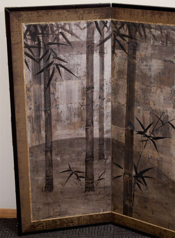 A Japanese folding screen in ink on silver (Sumie) with varnished oxide patina. The piece depicts bamboo trees and birds in flight