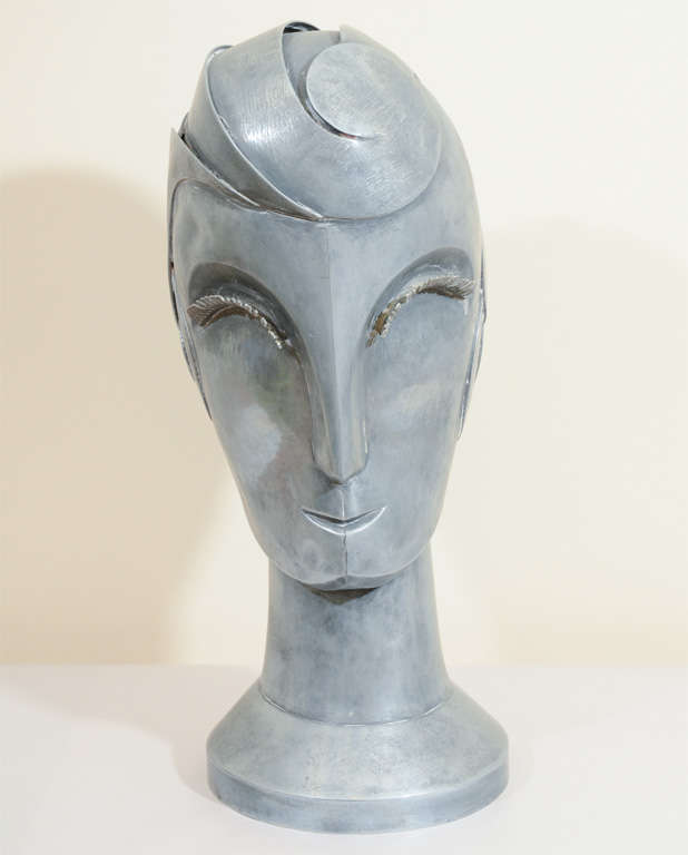 An Art Deco female bust with stylized features and great aged patina attributed to Walter Kantack. Her hair is a swirl of curving forms while her eyelashes are made up of thin strips of metal.

4478