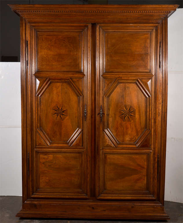 Early 19th century Italian walnut armoire, with inlaid on the doors. This is really a handsome piece with a gorgeous rich patina and star motif inlay.   Top shelf is removable to be able to store a T.V.