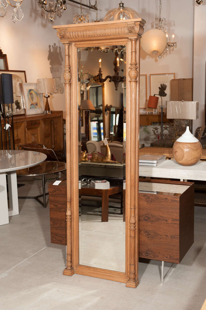 Carved hall mirror with symmetrical carvings in bare white oak.
Original bevelled glazing