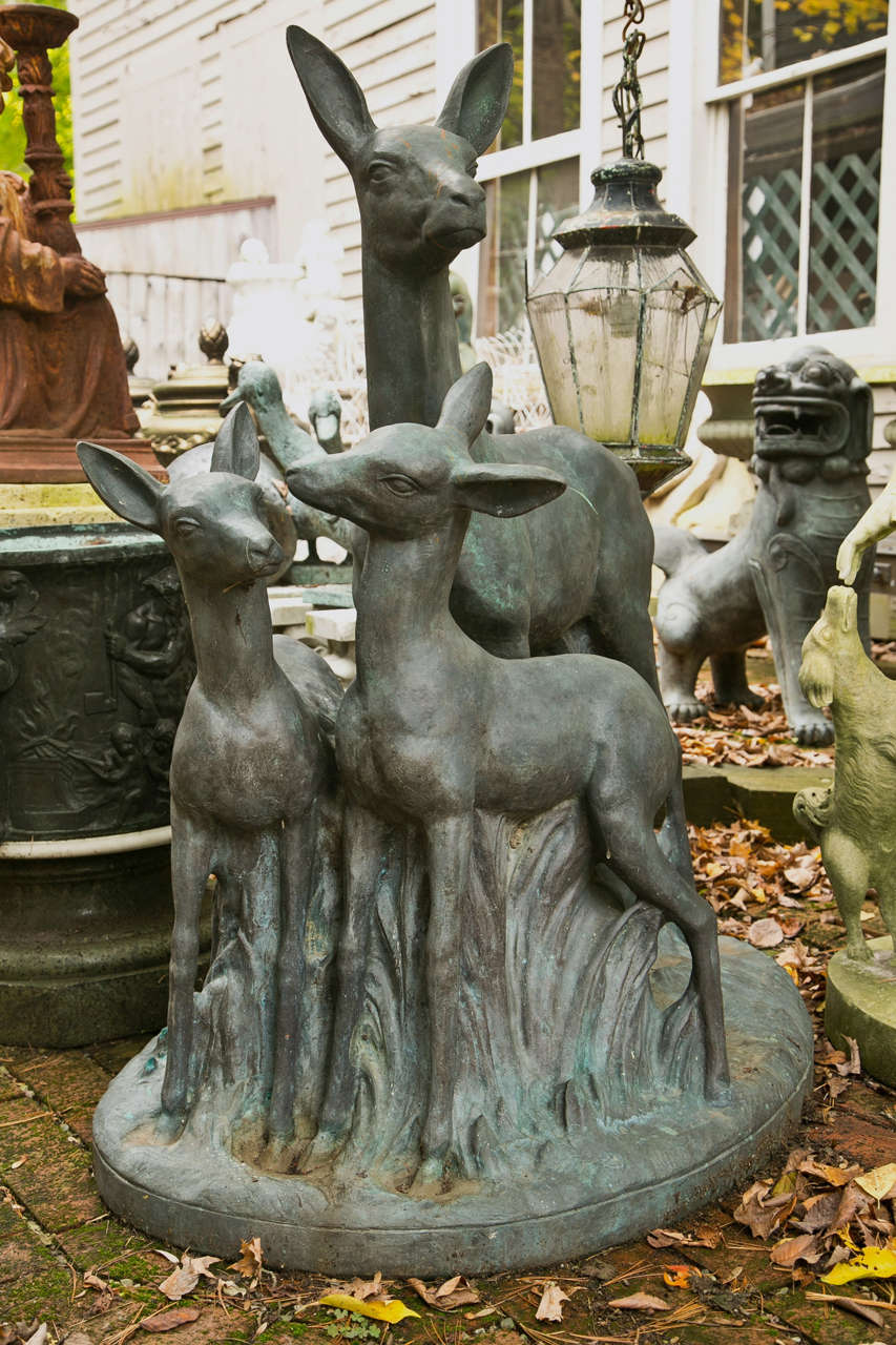 A single  cast bronze garden statue of a doe and her fawns in a  long leafy setting. Unsigned. beautifully patinated.. from Florentine Craftsmen, NYC