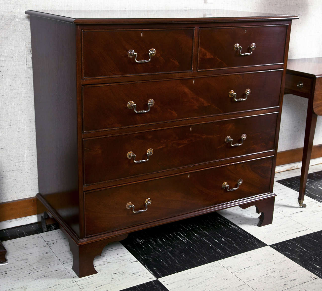 This Classic five-drawer chest has all the proper elements one seeks in such a piece. From the beaded drawers to the shaped bracket feet and including the brass bail hardware, it ticks off all the boxes. With beautiful crotch mahogany covering the