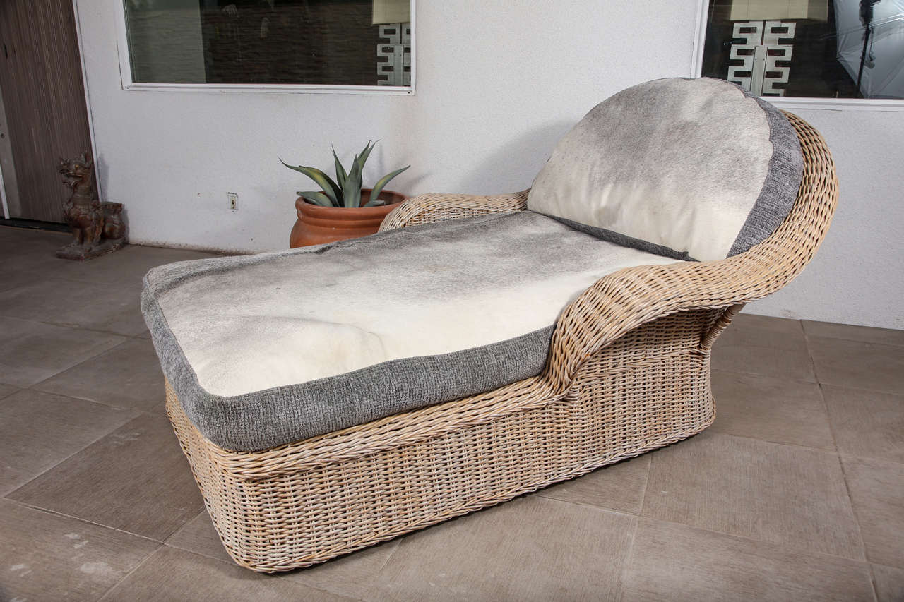 Large Rattan chaise lounge which has wonderful cowhide and chenille seat and back cushions.