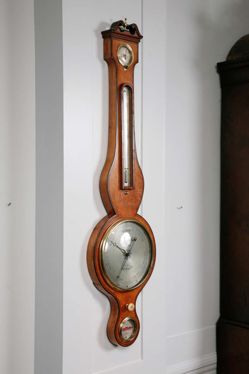 A fine George III period satinwood with mahogany banding wheel barometer, by J Thompson, Welbeck. The barometer has a swan-neck pediment above a circular hygrometer, and an arched silvered thermometer with a mercury tube. 

Below is an eight inch