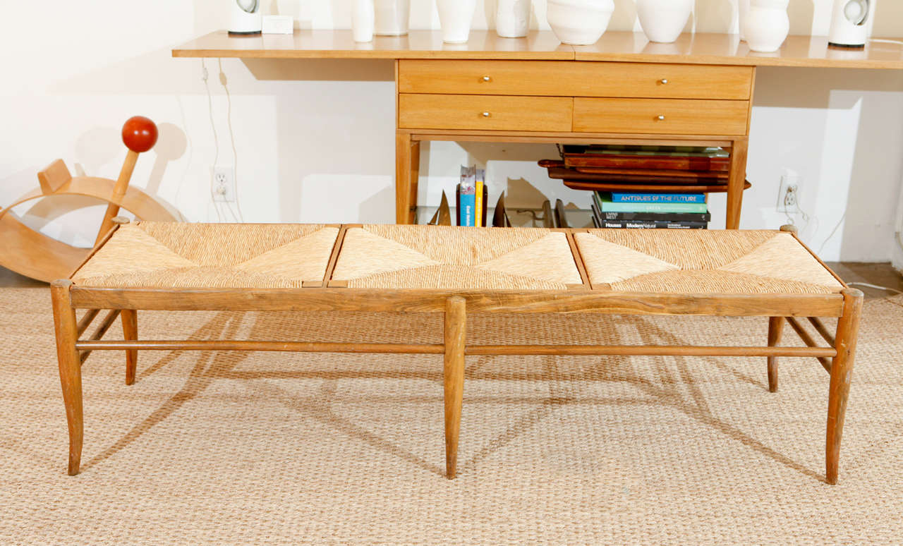 An exquisite Italian wood frame bench with rush seat in a natural wood finish.