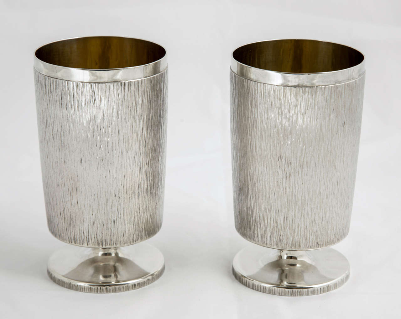 This pair of goblets are hallmarked London 1965 and were made by the pre-eminent silversmith of the time, Gerald Benney amongst whose clients were the Royal Family.
The beakers are 12.8cms high and together weigh 690gms.
They are decorated with